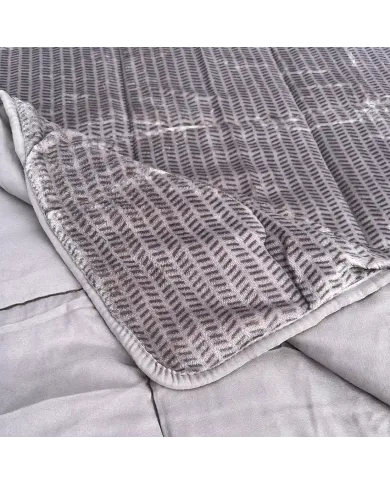 Close-up of a velvet bedspread with textured square stitching and contrasting underside.