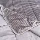 Close-up of a velvet bedspread with textured square stitching and contrasting underside.