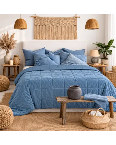 Warm, cosy bedroom with a velvet bedspread in blue on the bed.