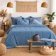 Een warme, knusse slaapkamer met een velvet dekbed zonder overtrek blauw op het bed.