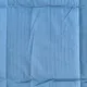 Close-up of a velvet bedspread showcasing the quilted square stitching.