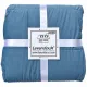 Folded blue velvet bedspread secured with white ribbons and labeled Lavandoux.