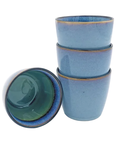 Blue cappuccino mugs stacked with one inverted to show green interior.